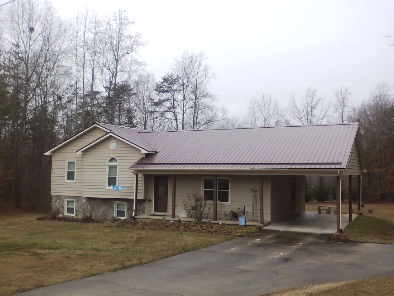 Burgundy metal roof on a tan split level home with an attached carport in Mellott