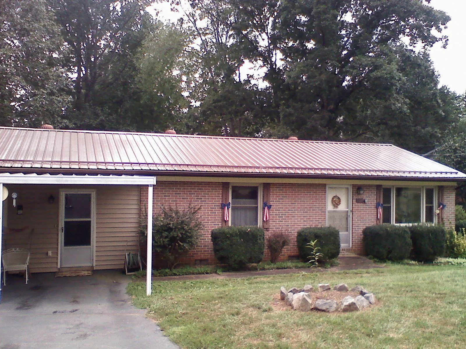 Bronze metal roof and carport on a brick ranch home — Roof Repair work by our crew in Mellott